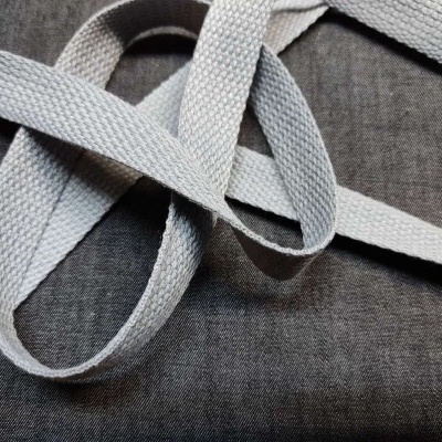 Fita de tecido cinza claro trançada sobre tecido cinza escuro