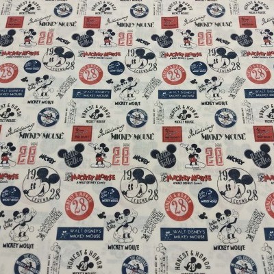 Tecido branco com desenhos do Mickey Mouse e textos em azul, vermelho e preto.