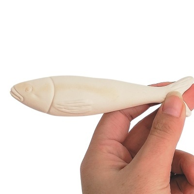 Peixe decorativo creme em cerâmica segurado pela mão