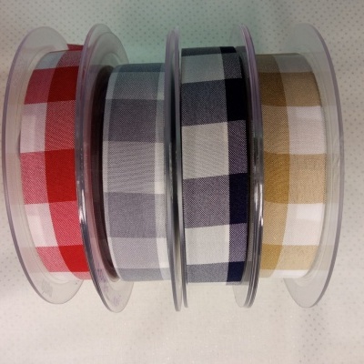 Fitas decorativas quadriculadas em rolos com cores variadas sobre fundo claro.