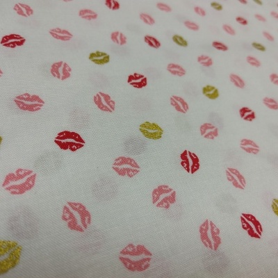 Tecido branco com padrão de lábios coloridos em rosa, vermelho e dourado