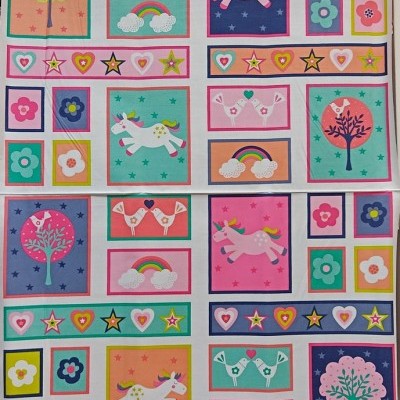 Tecido estampado com desenhos coloridos de corações, estrelas, árvores, pombas, unicórnios e arco-íris
