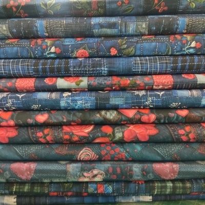 Pilha de tecidos com padrões florais e xadrez em azul, vermelho e verde