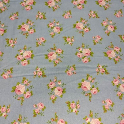 tecido azul claro com padrão de flores cor-de-rosa e folhas verdes