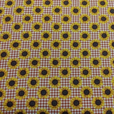 Pano com padrão de girassóis sobre fundo xadrez laranja e branco