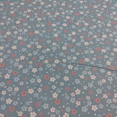 Tecido azul claro com padrão floral pequeno em rosa, branco e vermelho