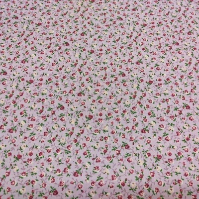 Tecido rosa claro com pequenas flores coloridas.