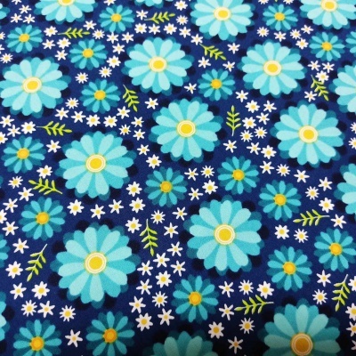 Tecido azul escuro com padrão de flores azuis, brancas e amarelas