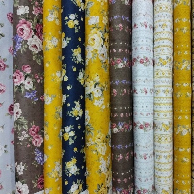 Rolos de tecido com padrões florais e geométricos em várias cores