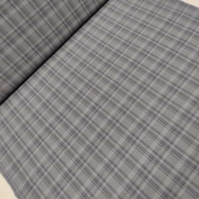 tecido cinzento xadrez enrolado sobre superfície clara