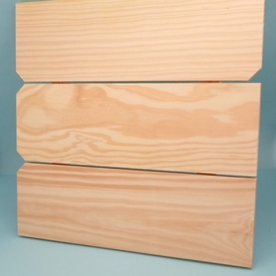 Três tábuas de madeira clara com cantos chanfrados empilhadas verticalmente