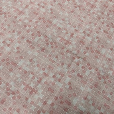 Tecido rosa claro com padrão de pequenos quadrados em tons variados de rosa e bege