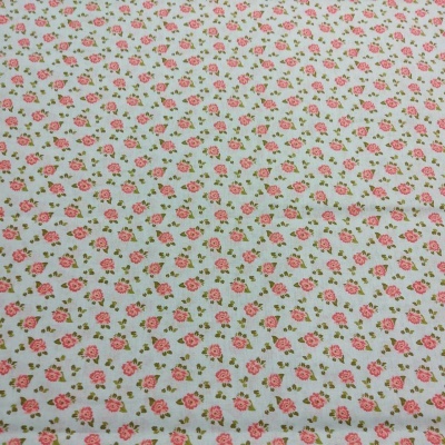 Tecido branco com padrão de flores cor-de-rosa e folhas verdes