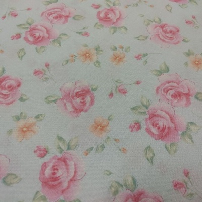 tecido branco com flores cor-de-rosa e cor-de-laranja com folhas verdes