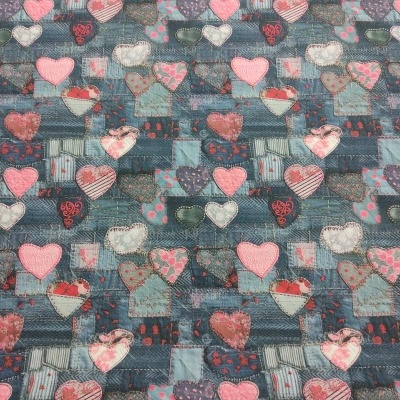 Tecido estampado com corações em vários tons sobre fundo azul.