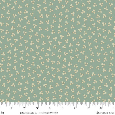 Tecido com estrelas bege em fundo verde-azulado, com régua de medidas em polegadas na base