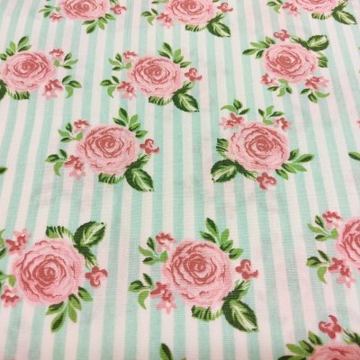 tecido com padrão de riscas azuis, brancas e rosas com rosas e folhas verdes