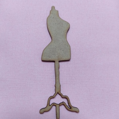 Miniatura de manequim de costura em madeira sobre fundo rosa