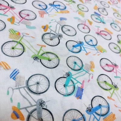 tecido branco com padrão de bicicletas coloridas e acessórios