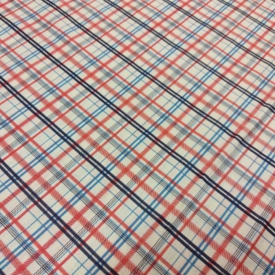 Tecido xadrez com linhas vermelhas, azuis e pretas sobre fundo branco