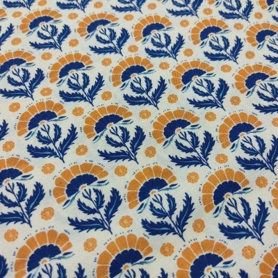 tecido branco com padrão floral azul escuro e laranja