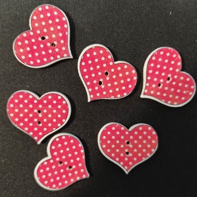 Botões cor-de-rosa com bolinhas brancas em forma de coração