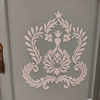 Porta de móvel cinza com decoração floral branca em relevo