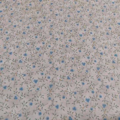 Tecido branco com padrão de pequenas flores azuis e folhas verdes