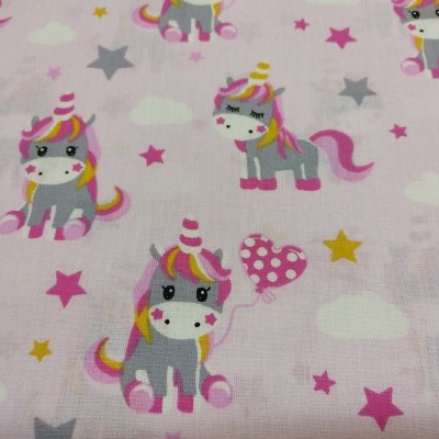 Tecido cor-de-rosa com unicórnios, estrelas e nuvens num padrão colorido