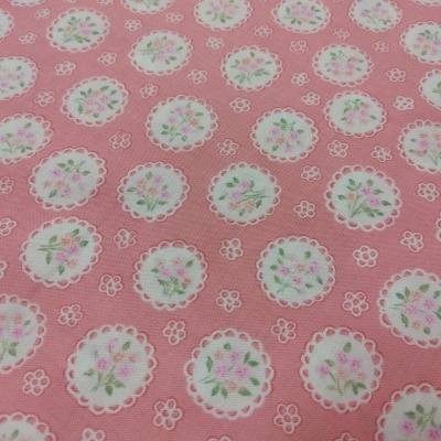 Tecido rosa com padrão floral repetido em círculos brancos