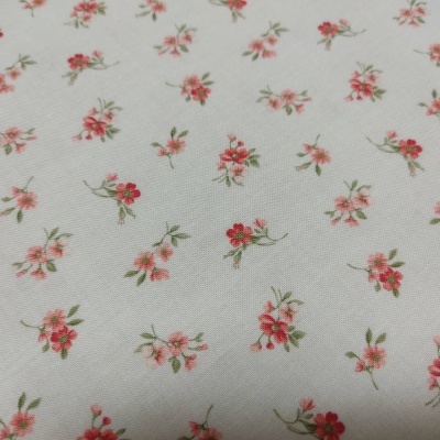 Tecido branco com padrão floral pequeno em vermelho e rosa