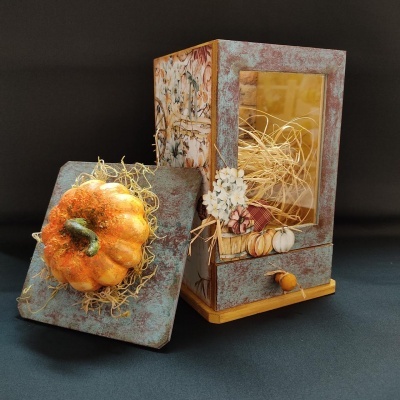 lanterna decorativa em madeira com abóbora laranja e ornamentos de flores e palha