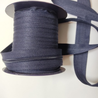 Rolo de fita azul escura com fecho de correr em superfície branca