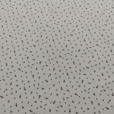 Tecido branco com padrão de pequenas folhas pretas distribuídas uniformemente