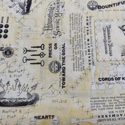 Tecido bege estampado com motivos e textos de costura