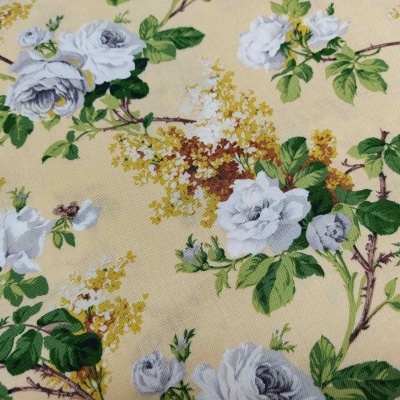 tecido floral bege com rosas brancas e folhas verdes