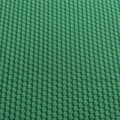 Tecido verde com pequeno padrão floral branco e amarelo