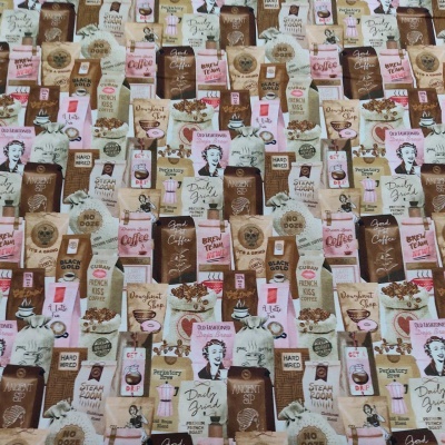 Pano estampado com imagens e textos relacionados a café em tons castanhos e rosa
