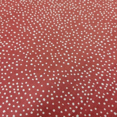 tecido vermelho com pontos brancos pequenos e irregulares