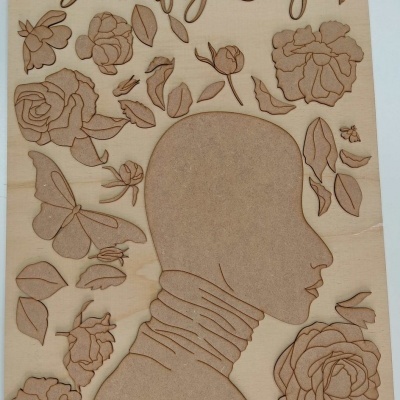 Peça decorativa em madeira com silhueta feminina e elementos florais