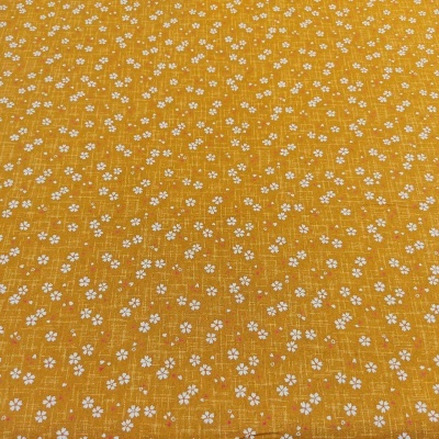 tecido amarelo com pequenas flores brancas