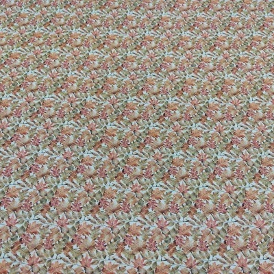 Tecido com padrão floral em tons castanhos, verdes e laranja.