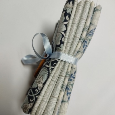 Conjunto de tecidos dobrados com padrões florais amarrados com fita