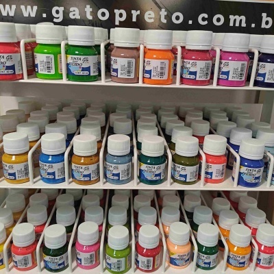 Frascos pequenos de tinta acrílica colorida organizados em prateleiras