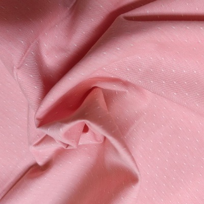 Tecido cor-de-rosa com pontos brancos e textura enrugada
