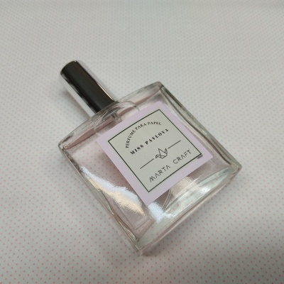 Frasco de perfume transparente com tampa preta e etiqueta branca