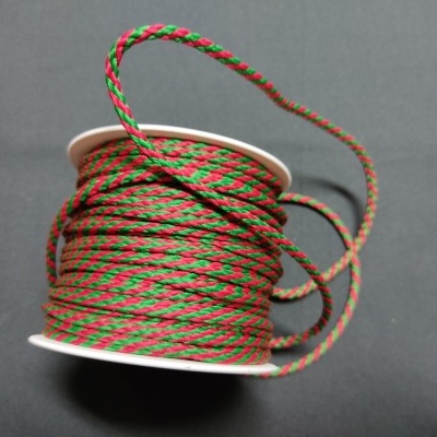 Rolo de corda trançada verde e vermelha sobre fundo cinza