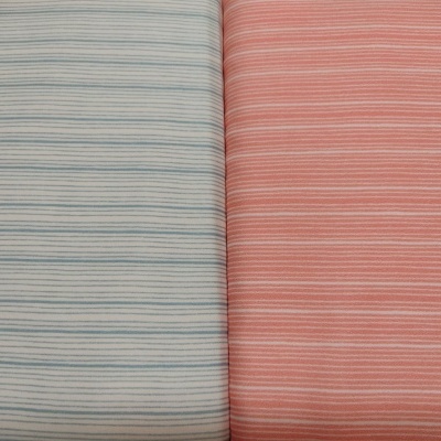Dois tecidos lisos com pequenas listras horizontais, um bege com azul e outro coral com branco