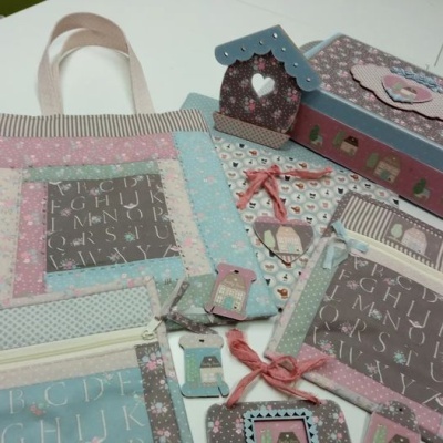 Itens de tecido decorativos com padrão de casas e letras em cores pastel