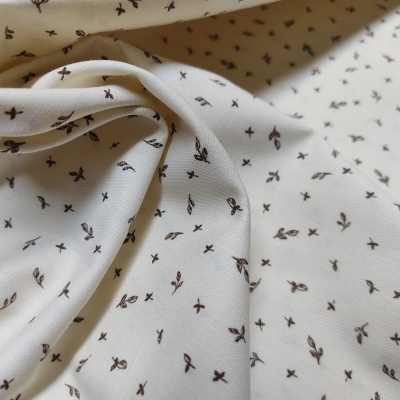 Tecido branco com padrão de pequenas flores marrons